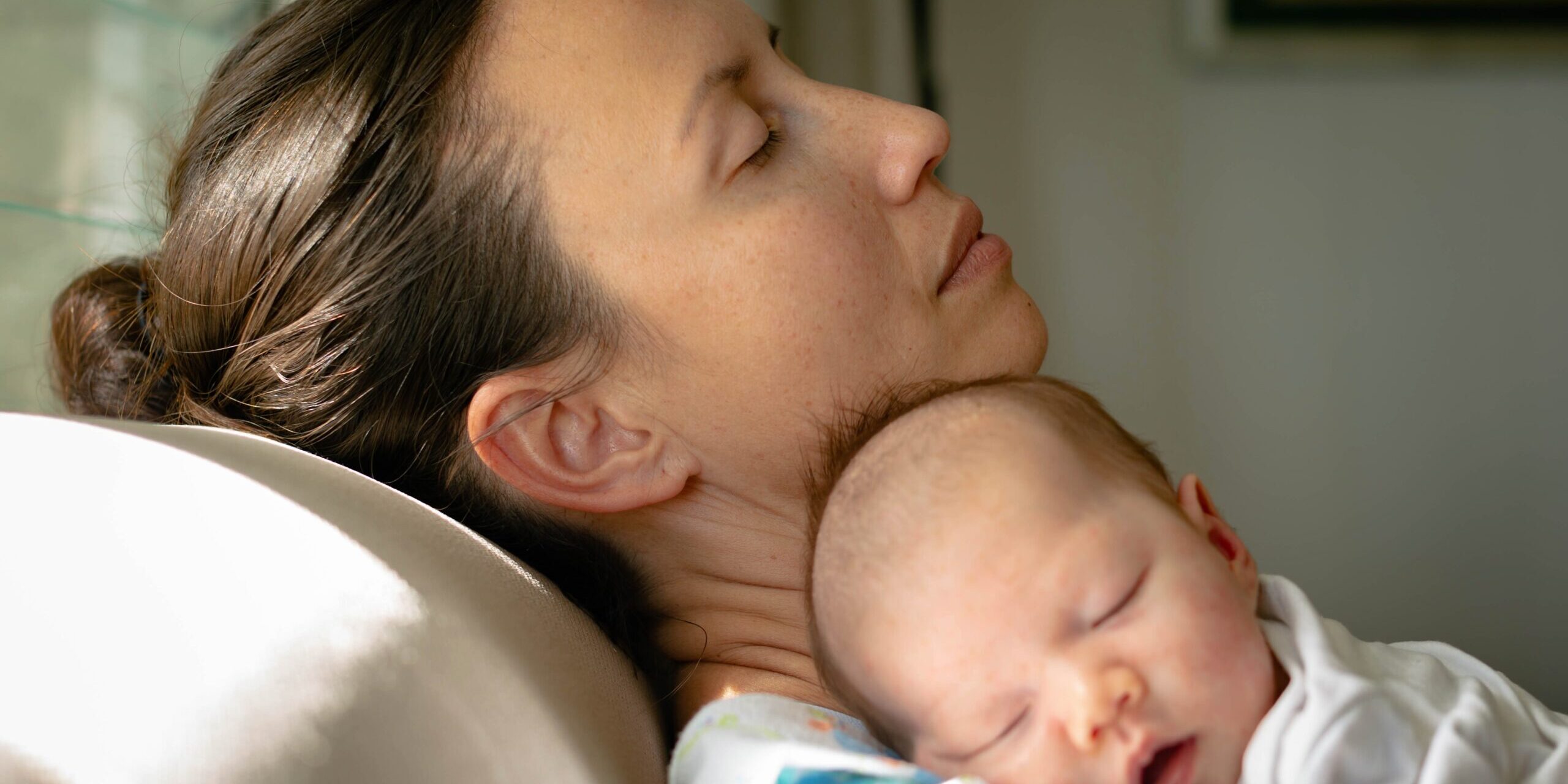 a depressed overwhelmed and tired mom taking care of her baby at home.